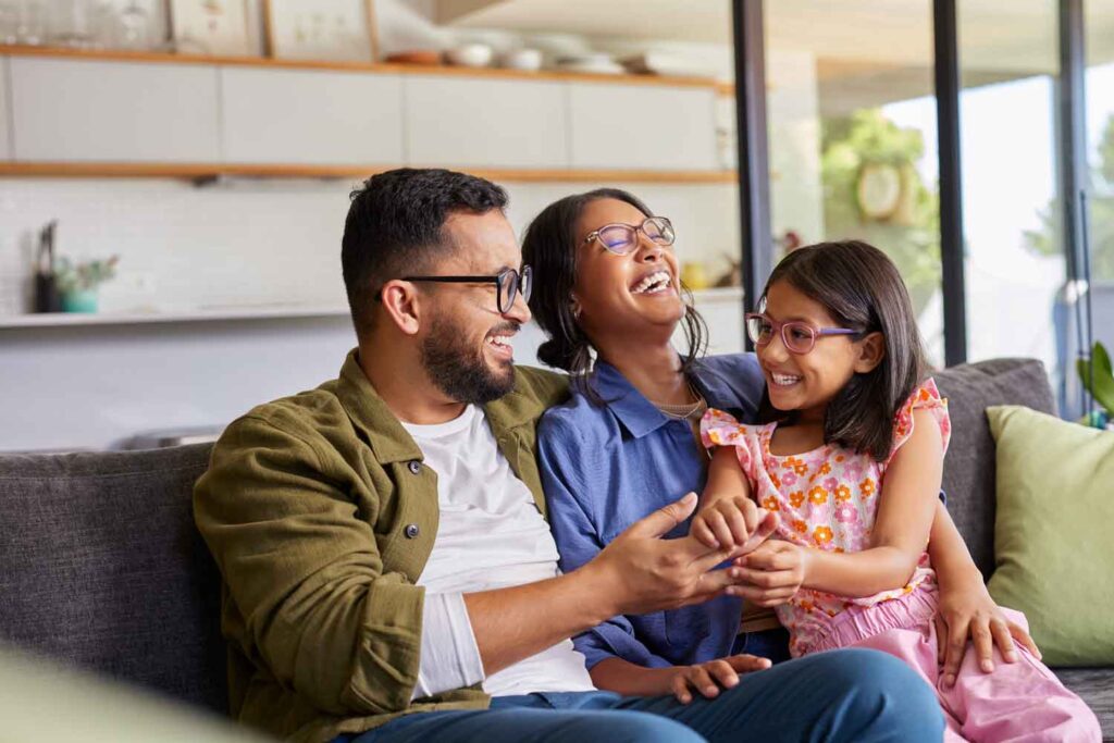 Young family sitting together on sofa